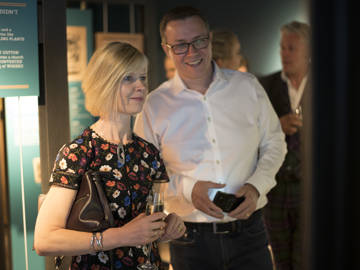 Guests holding Champagne flutes browsing our Dockside Story 