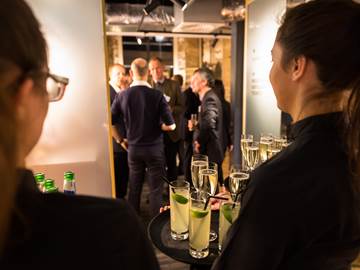 Waiters holding trays of drinks while guests enter reception area to The Clydeside Distillery 