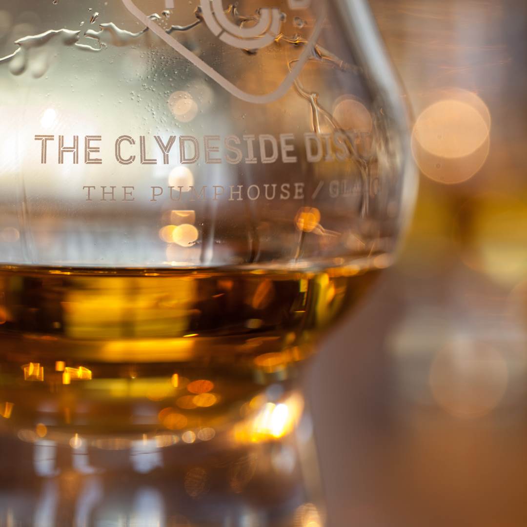 Dram of whisky in large, branded glass 